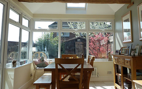 The inside of a conservatory furnished with wooden table and side table